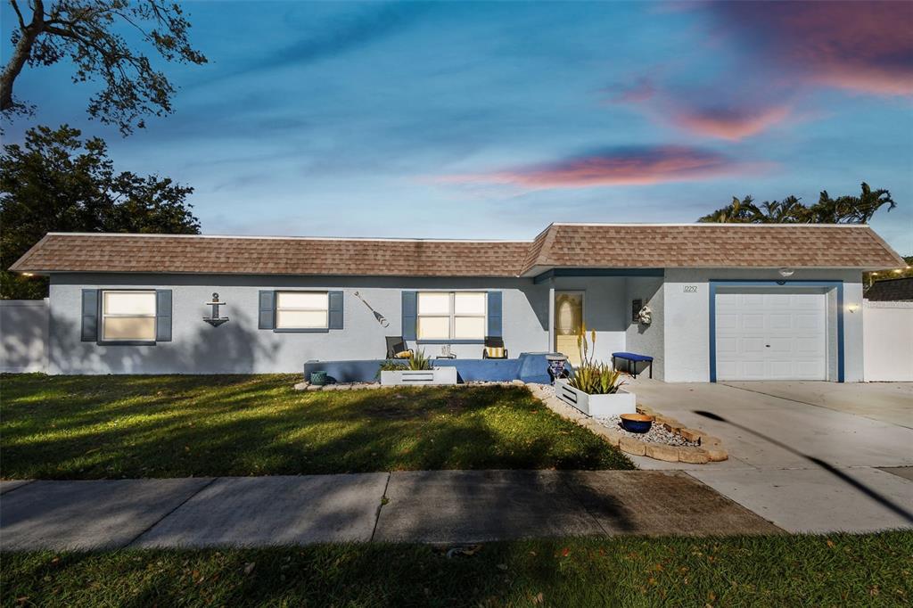 A single-story house with a light blue exterior, a brown shingled roof, and a garage — 12252 ELDON DRIVE, LARGO, FL