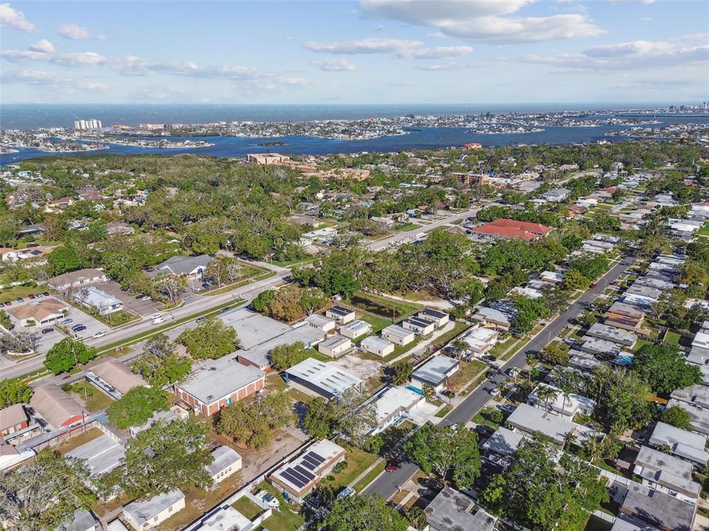 An aerial view shows a residential neighborhood with flat-roofed buildings and nearby coastal waterways — 12252 ELDON DRIVE, LARGO, FL