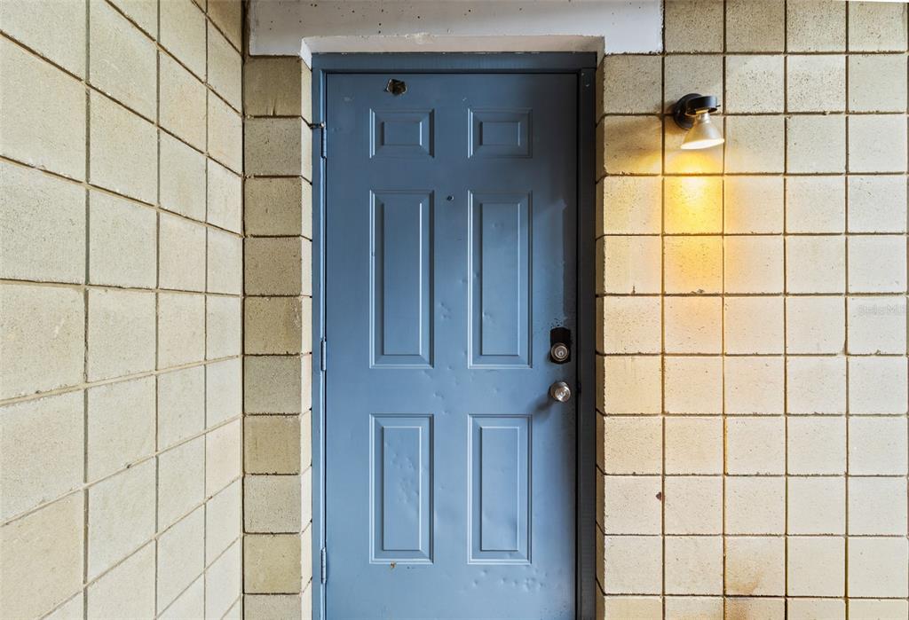 A blue six-panel door is set into a wall made of light-colored concrete blocks — 4705 SW 69TH TERRACE, GAINESVILLE, FL