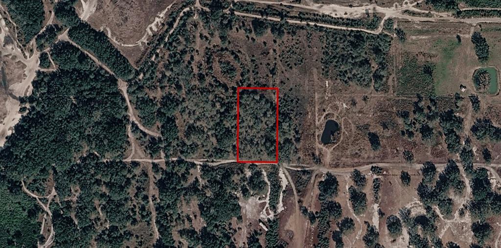 An aerial view shows a rectangular plot of land outlined in red amidst wooded terrain — 300TH STREET, OKEECHOBEE, FL