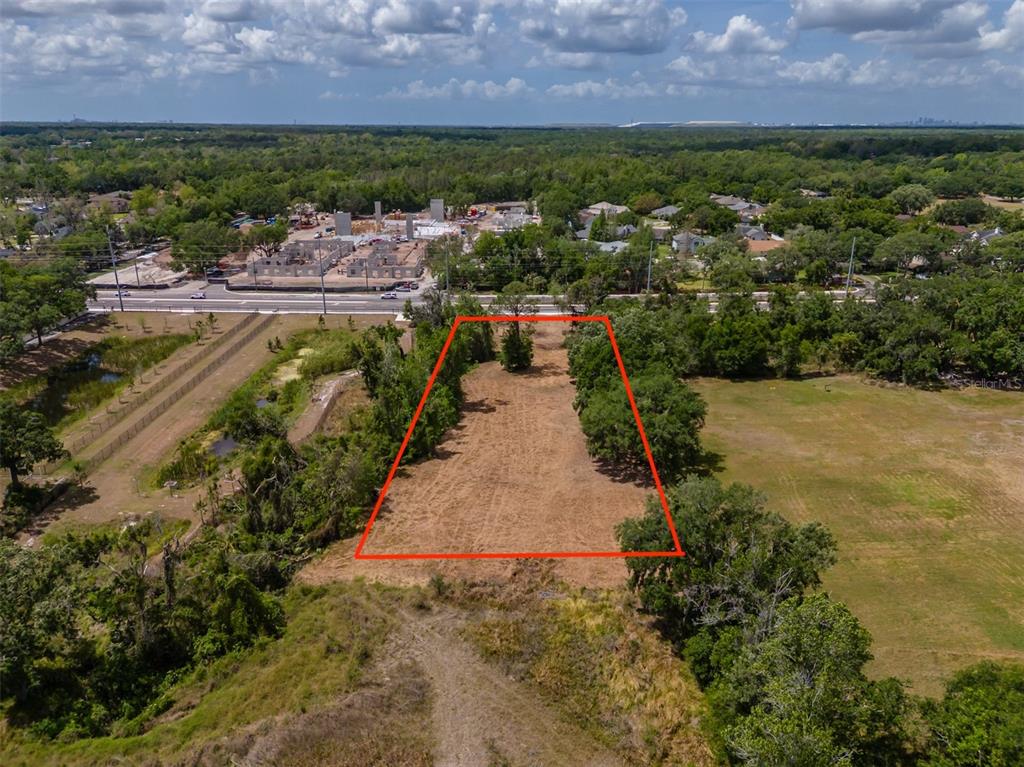 An aerial view shows a rectangular, cleared lot outlined in red amidst trees and fields — 5106 BELL SHOALS ROAD, VALRICO, FL