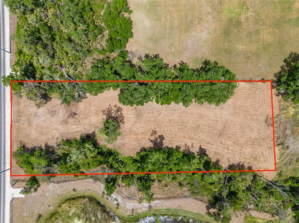 An aerial view shows a rectangular, cleared vacant lot bordered by trees and a road — 5106 BELL SHOALS ROAD, VALRICO, FL