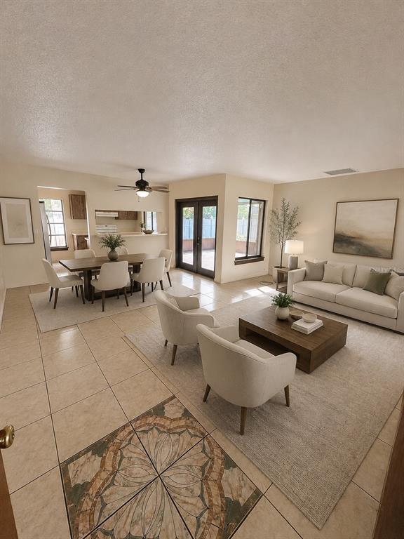 An open-concept living and dining area features tile flooring, neutral furniture, and French doors — 11 TROPHY LANE, KISSIMMEE, FL
