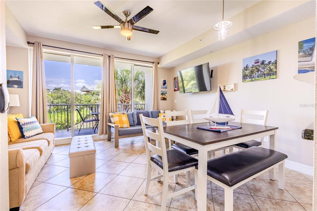 A living and dining area features tile floors, a ceiling fan, and a balcony view — 3259 MANGROVE POINT DRIVE, RUSKIN, FL