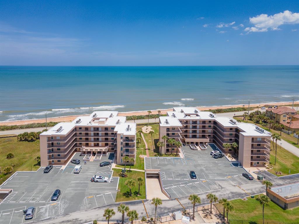 An aerial view shows two multi-story apartment buildings with parking lots located near the ocean — 3360 OCEAN SHORE BOULEVARD UNIT 3040, ORMOND BEACH, FL