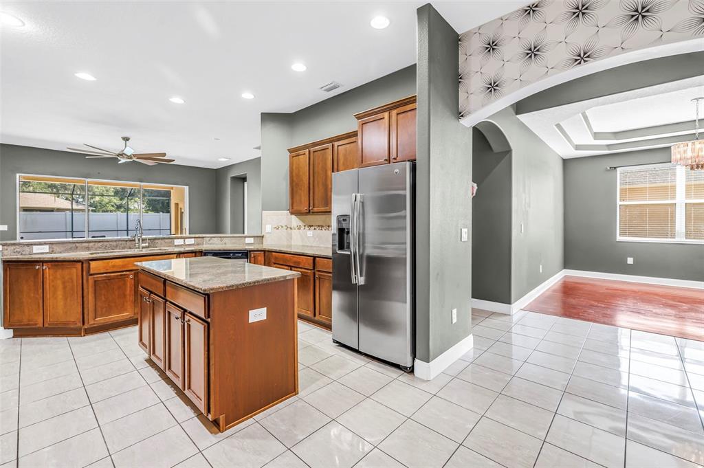 A laundry room features white appliances, open shelving, wall art, and a hanging basket — 27405 SORA BOULEVARD, WESLEY CHAPEL, FL