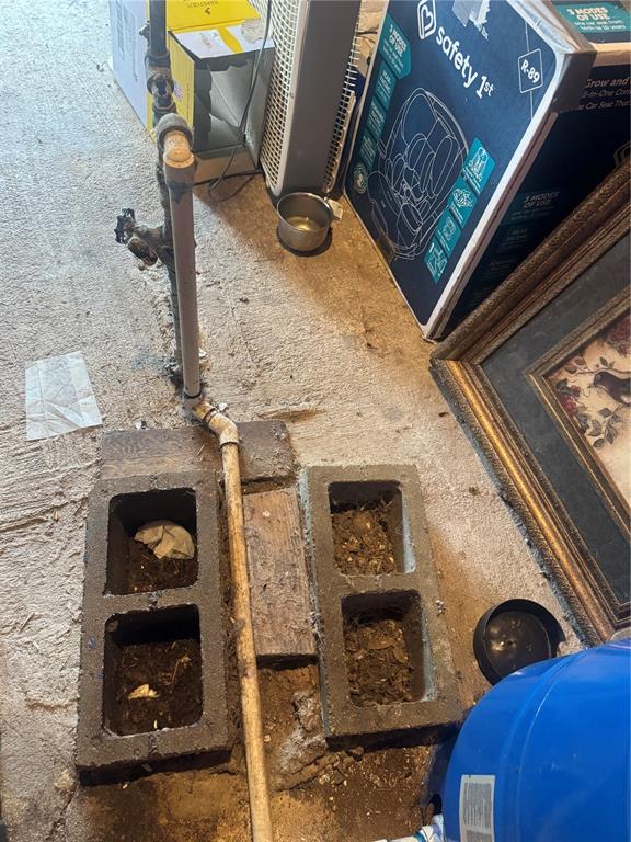 A basement corner shows a vertical pipe, concrete blocks, and various household items on concrete — 2031 SE 191ST TERRACE, MORRISTON, FL