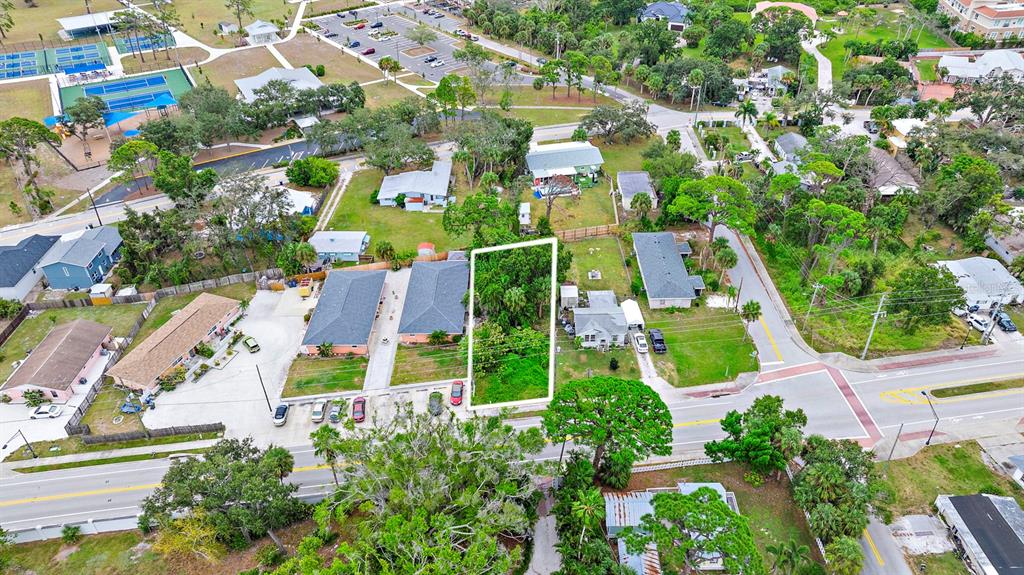 An aerial view shows a vacant, rectangular lot surrounded by residential buildings and paved roads — COLONIA LANE, NOKOMIS, FL