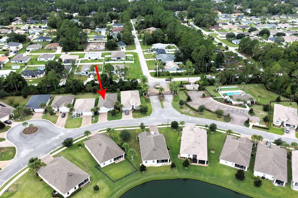 A single-story house with a white exterior, a garage, and a front yard with trees — 107 PARK PLACE CIRCLE, PALM COAST, FL