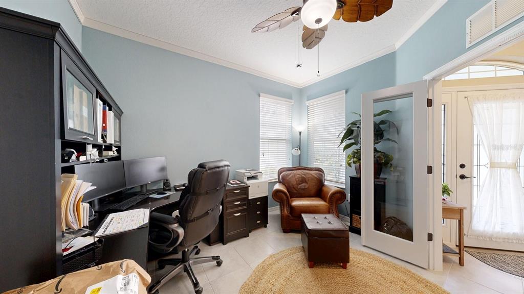 A bright open-concept living room features a kitchen with white cabinets and a vaulted ceiling — 107 PARK PLACE CIRCLE, PALM COAST, FL