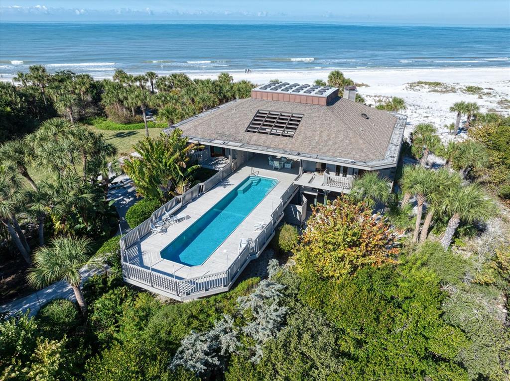 An aerial view of a beachfront house featuring a long rectangular pool on a deck — 1198 MANDALAY POINT, CLEARWATER, FL