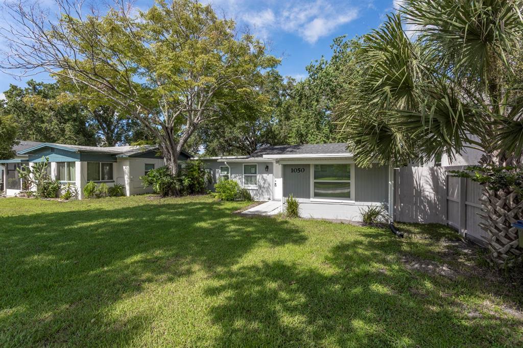 A single-story house with light gray siding and a large front lawn under mature trees — 1050 HERMAN AVENUE, ORLANDO, FL