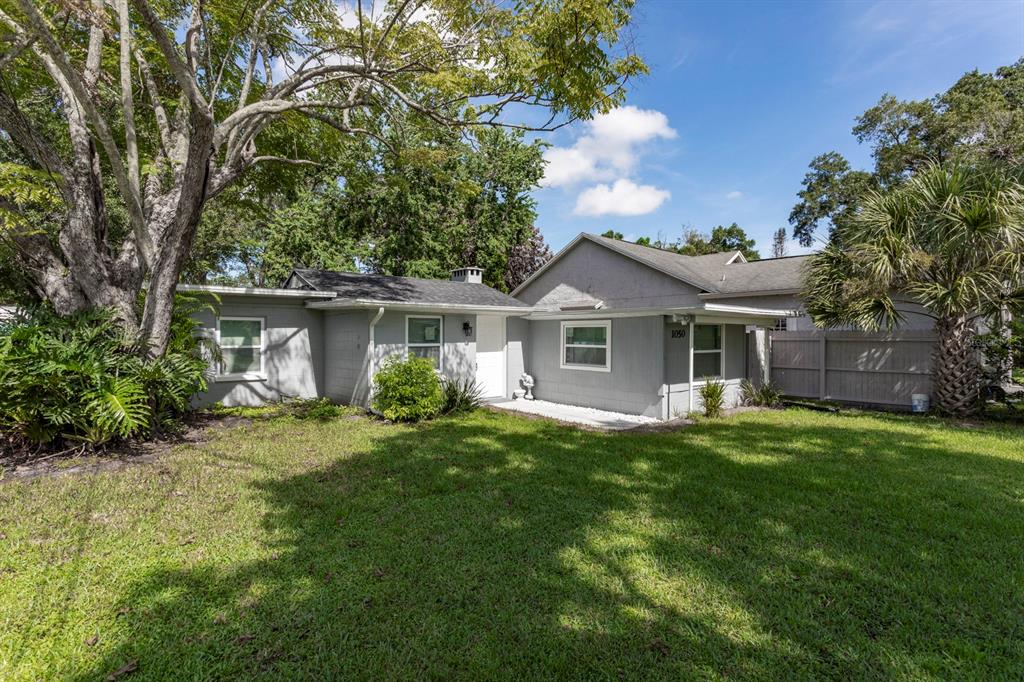A gray single-story house with a white front door and a large tree in front — 1050 HERMAN AVENUE, ORLANDO, FL