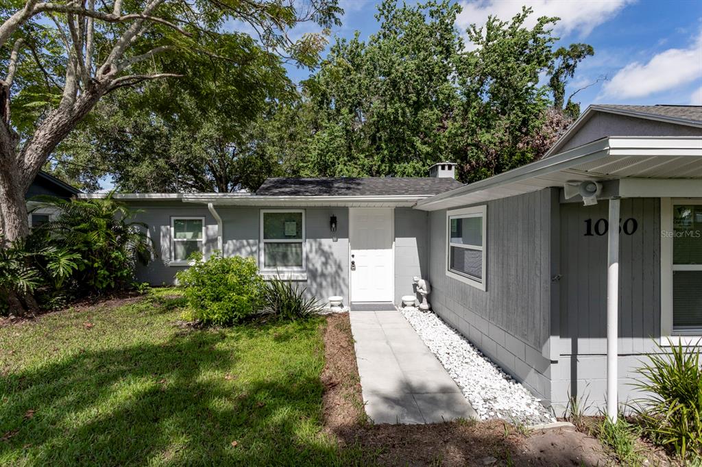 A gray single-story house with a white front door and a white stone walkway — 1050 HERMAN AVENUE, ORLANDO, FL