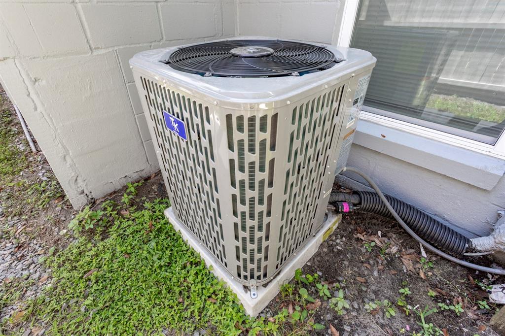 An outdoor air conditioning condenser unit sits on a concrete pad beside a building wall — 1050 HERMAN AVENUE, ORLANDO, FL