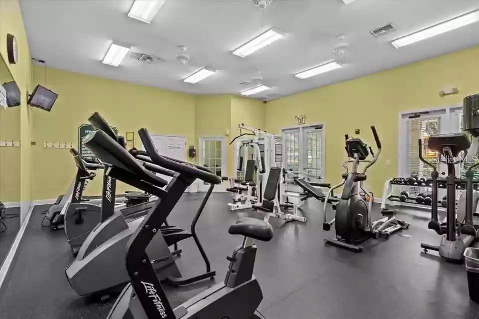 An empty room features wood-look flooring, white walls, a ceiling fan, and a large window — 4006 SANTA MARIA DRIVE UNIT 108, KISSIMMEE, FL