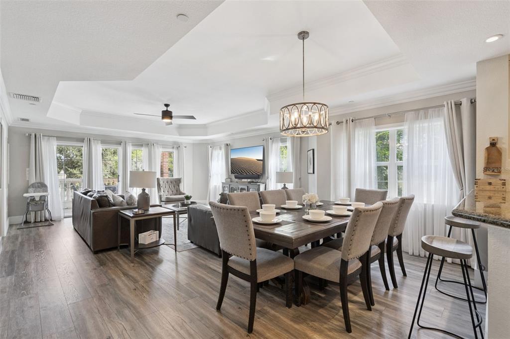 A covered balcony features a glass-top table with four chairs and a stone balustrade railing — 7651 WHISPER WAY UNIT 204, REUNION, FL