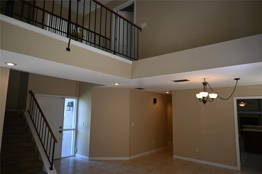 A two-story foyer features a staircase, a balcony railing, and a hanging chandelier — 1142 ODAY DRIVE, WINTER SPRINGS, FL