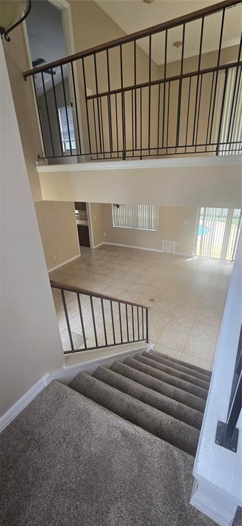 A view from a carpeted staircase looking down into an open living area with tile floors — 1142 ODAY DRIVE, WINTER SPRINGS, FL