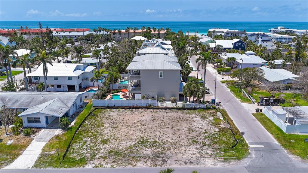 An aerial view shows a vacant, sandy lot situated in a residential coastal neighborhood — 6406 HOLMES BOULEVARD, HOLMES BEACH, FL