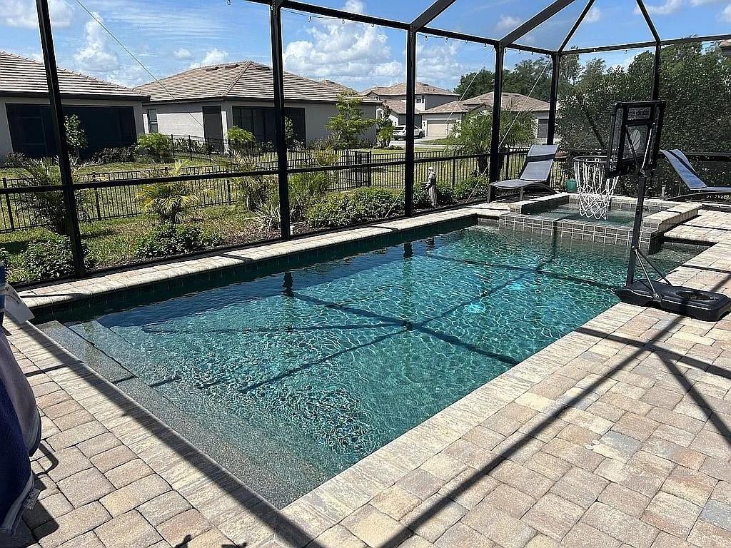 A two-story suburban house with beige siding, a tiled roof, and a front-facing garage — 15008 MISTY WATER CROSSING, BRADENTON, FL