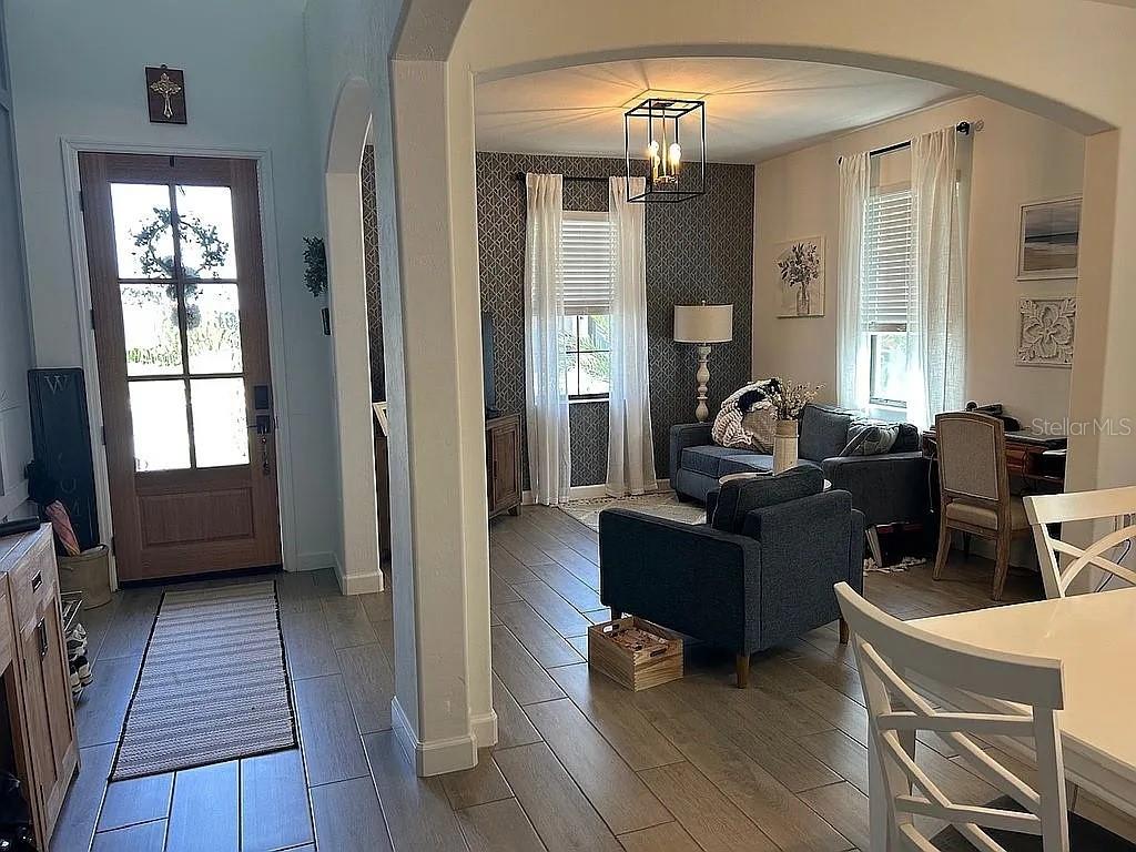 A gray front door with glass panels and a wreath sits in a stucco entryway — 15008 MISTY WATER CROSSING, BRADENTON, FL