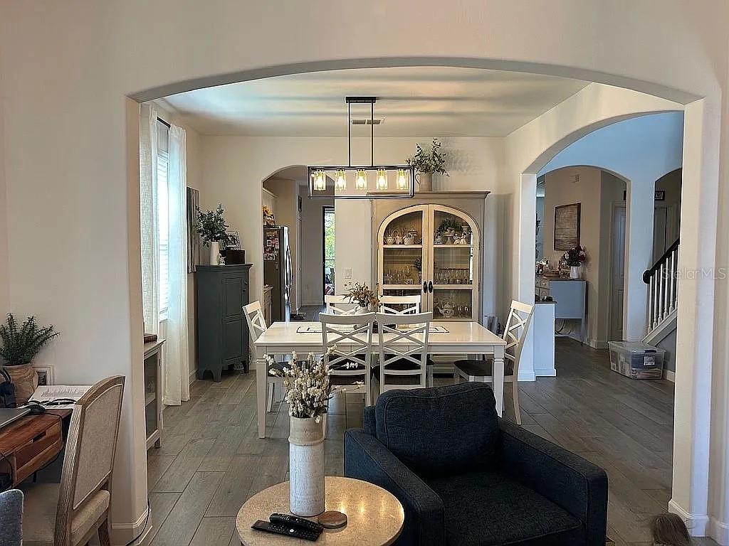 A bright entryway features a wood console table, gray board-and-batten walls, and a staircase — 15008 MISTY WATER CROSSING, BRADENTON, FL