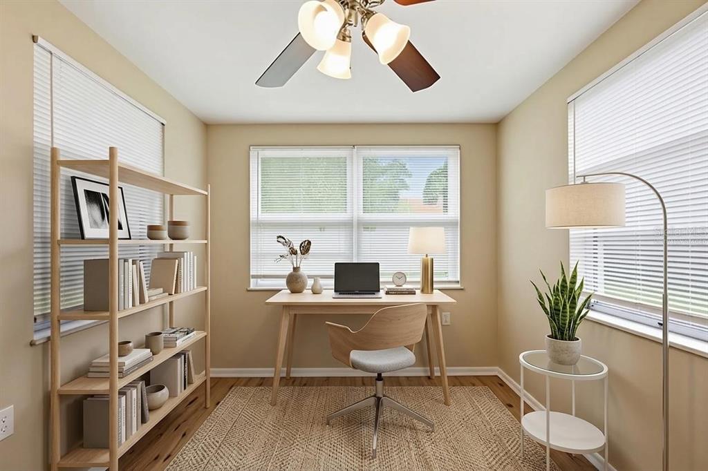 A home office features a wooden desk, bookshelf, area rug, and windows with white blinds — 3319 CANTRELL STREET, HOLIDAY, FL
