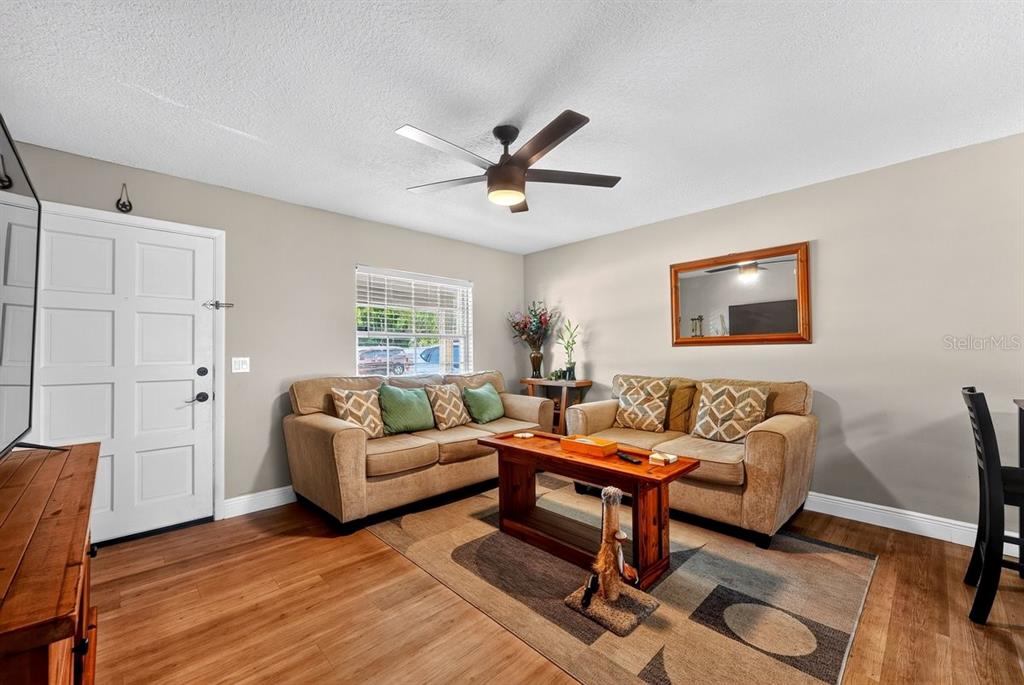 A living room features two beige sofas, a wooden coffee table, and a ceiling fan — 880 SEMINOLE AVENUE, LONGWOOD, FL