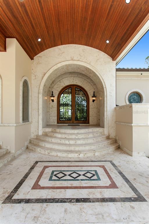 An arched entryway features stone steps, a wood-paneled ceiling, and a decorative tiled floor — 7850 FOUR PINES ROAD, PLANT CITY, FL