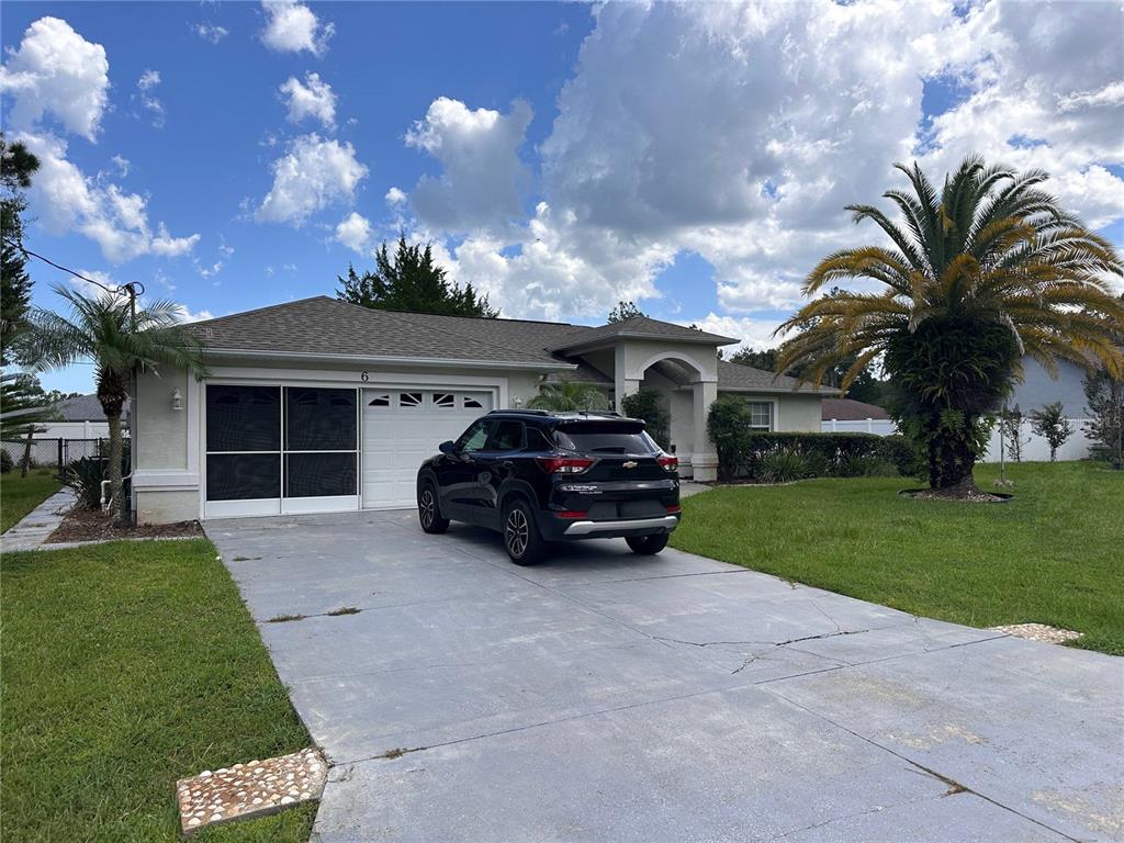 A single-story house with a screened garage and a black SUV parked in the driveway — 6 WHITE HOUSE DRIVE, PALM COAST, FL