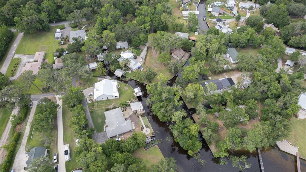 Aerial view of houses situated along a narrow canal surrounded by dense trees and vegetation — 8211 COLEE COVE BRANCH ROAD, ST AUGUSTINE, FL
