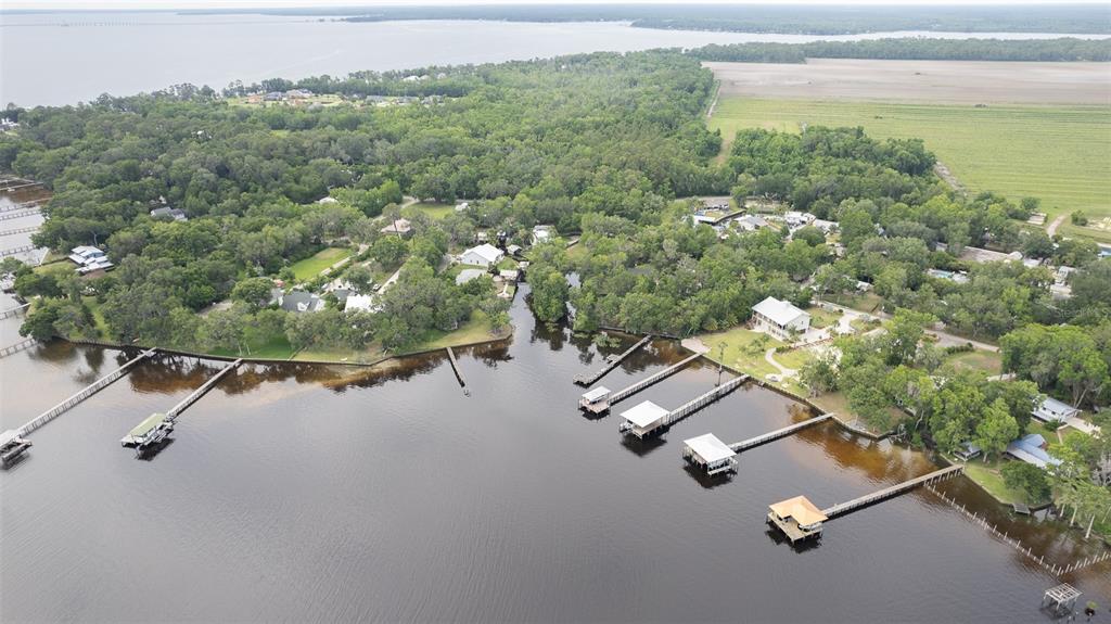 An aerial view shows waterfront homes with private docks along a tree-lined shore — 8211 COLEE COVE BRANCH ROAD, ST AUGUSTINE, FL