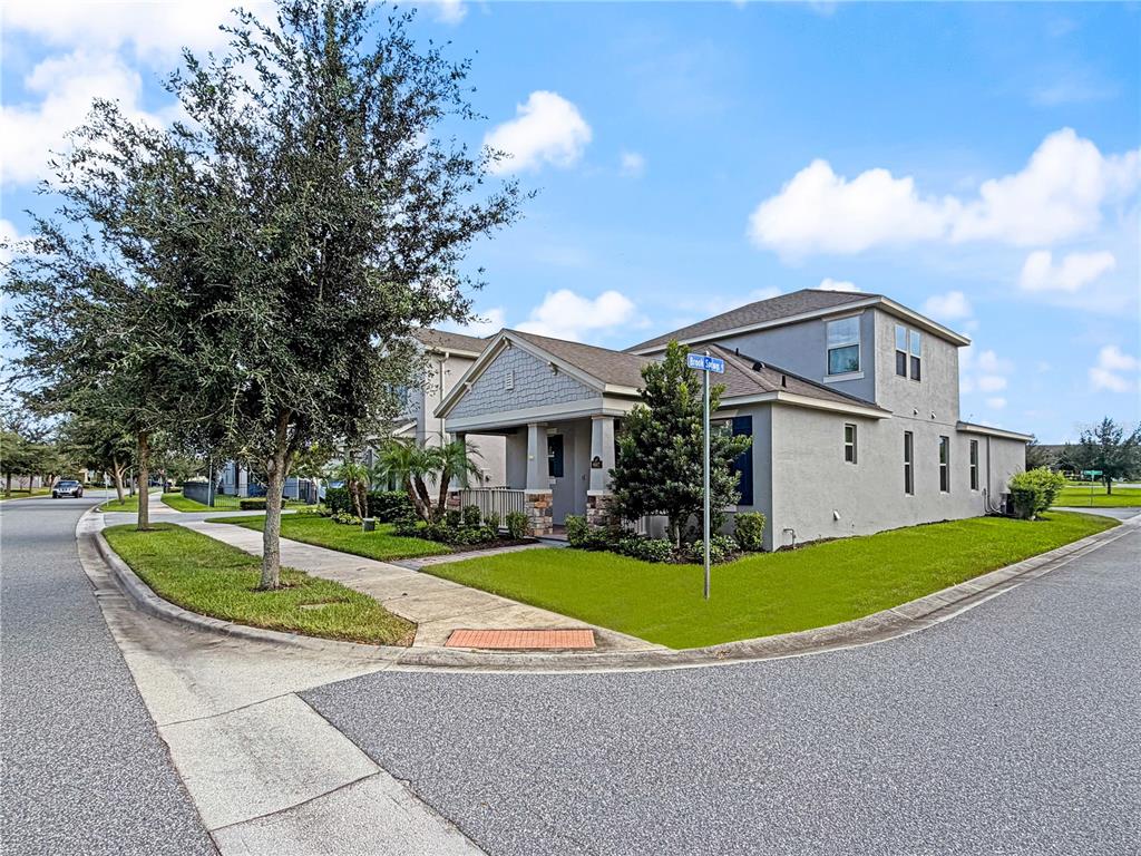 A two-story suburban house with a covered porch sits on a corner lot — 9662 WATERWAY PASSAGE DRIVE, WINTER GARDEN, FL
