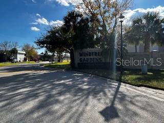 A street-level view shows the entrance sign for Windtree Gardens with trees and a lamp — 92 WINDTREE LANE UNIT 201, WINTER GARDEN, FL