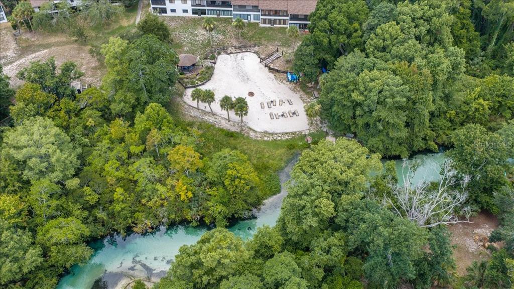 An aerial view shows a multi-story residential building complex adjacent to a large wooded area — 6653 RIVER RUN BOULEVARD, WEEKI WACHEE, FL