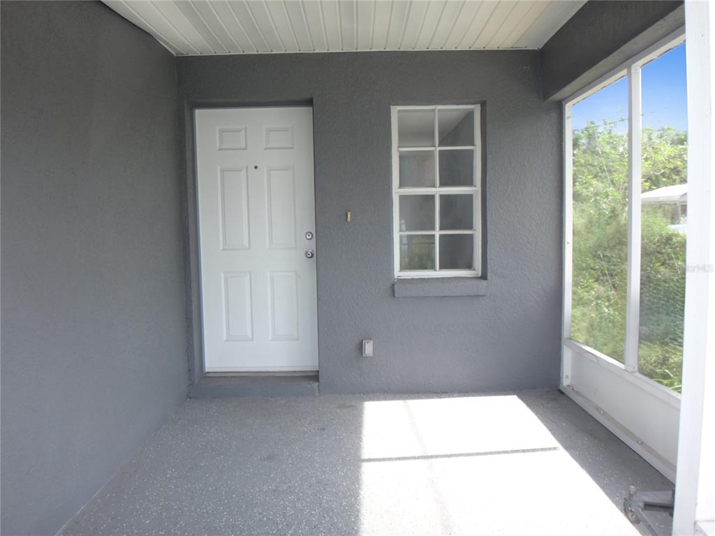An open-concept kitchen and living area features gray walls, wood-look flooring, and stainless steel appliances — 1125 BRITTS LANE, BARTOW, FL