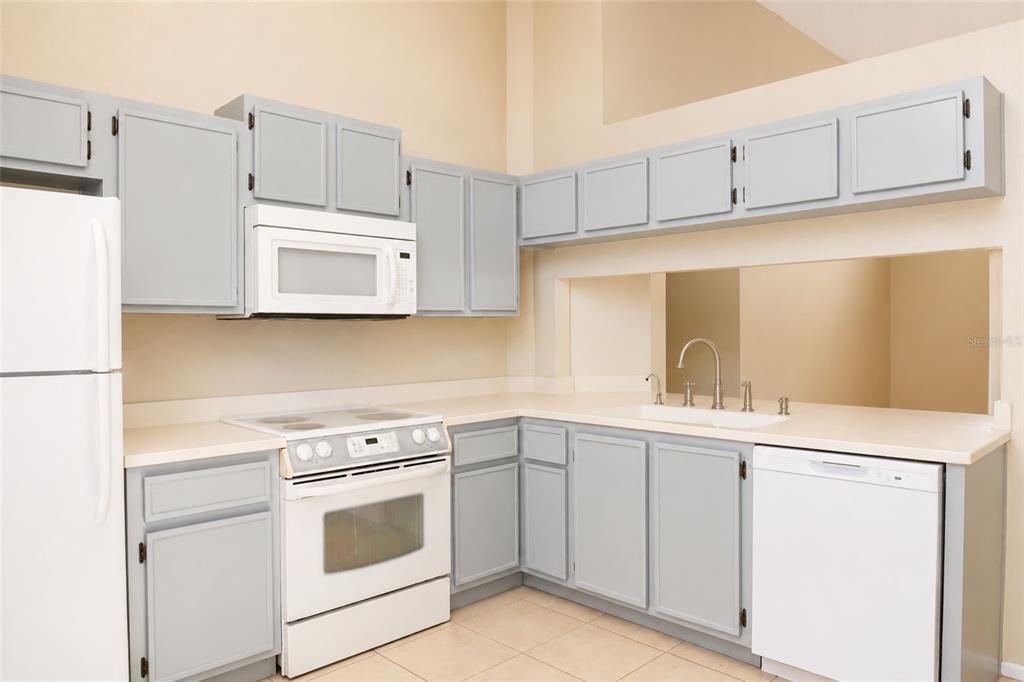 A kitchen with gray cabinets, white appliances, and light-colored countertops — 4631 W EASTWIND DRIVE, PLANT CITY, FL