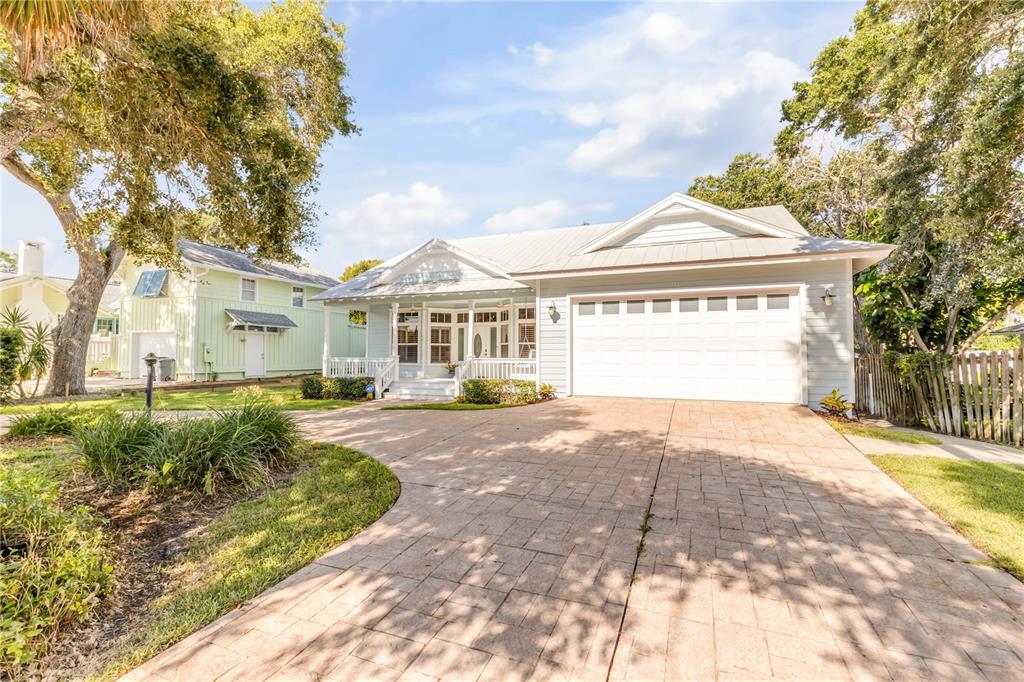 A light blue single-story house with a white garage and a paved driveway — 410 S PENINSULA AVENUE, NEW SMYRNA BEACH, FL