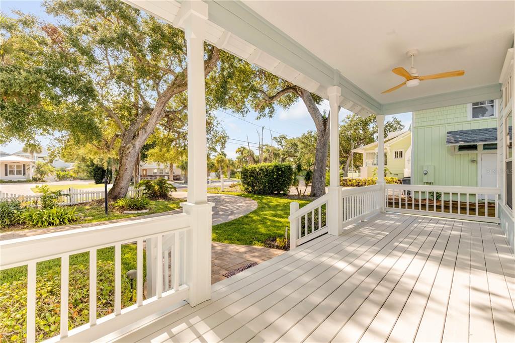 A covered porch with white railings, a ceiling fan, and a view of the yard — 410 S PENINSULA AVENUE, NEW SMYRNA BEACH, FL