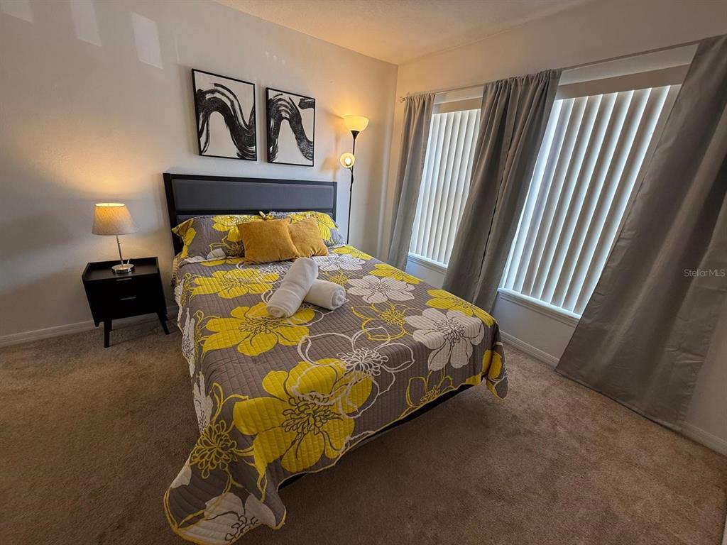 A bathroom features a vanity with a white countertop, a mirror, and a separate tub-shower — 2776 CLUB CORTILE CIRCLE UNIT A, KISSIMMEE, FL