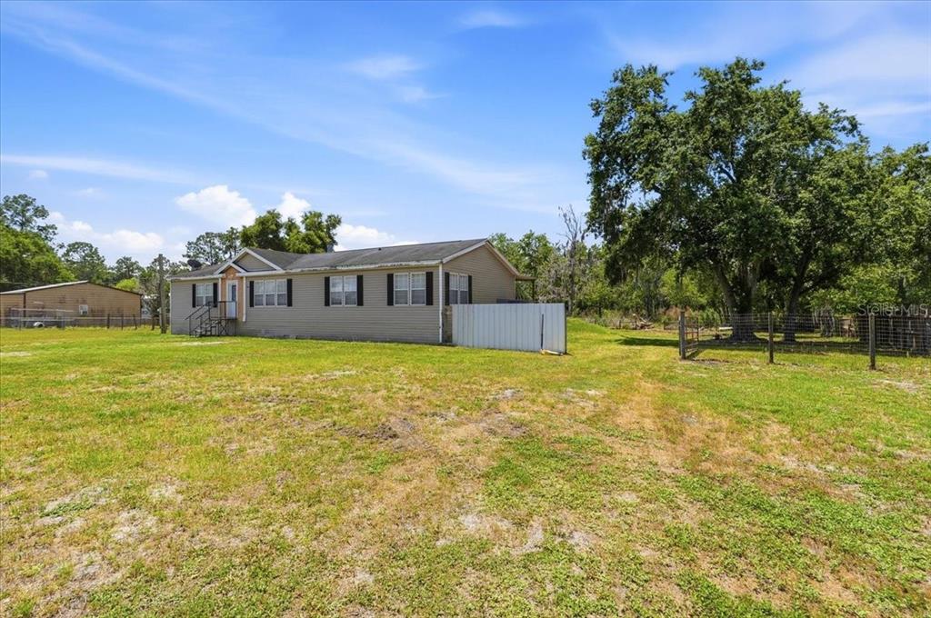 An aerial view shows a rectangular property with a house, outbuildings, and surrounding trees — 10724 PATHFINDER TRAIL, LAKELAND, FL