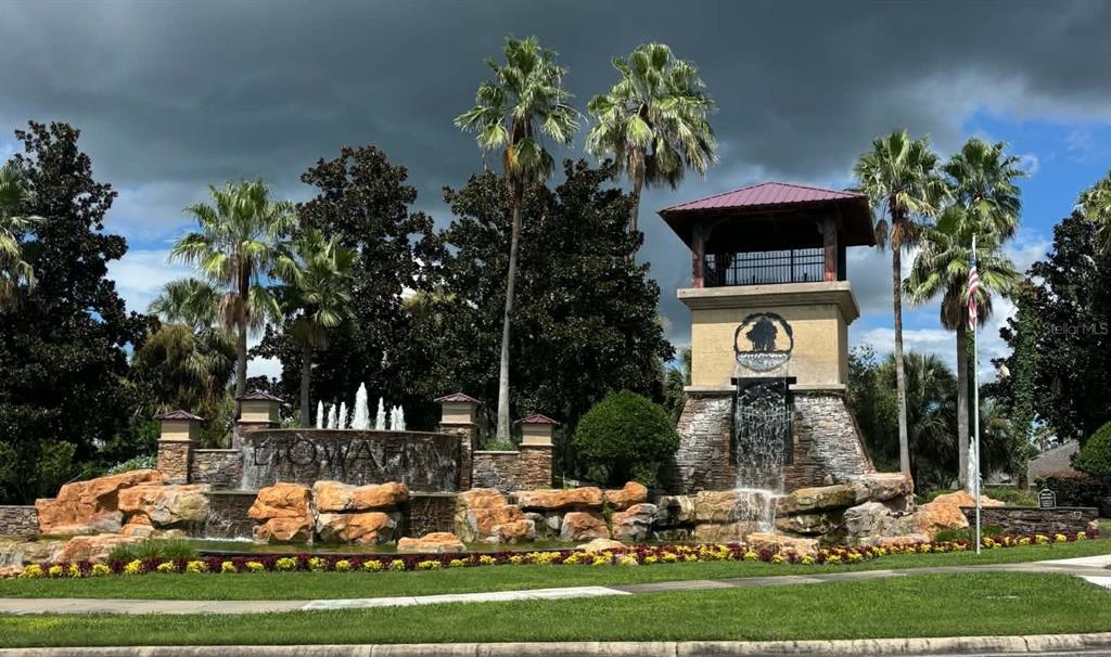 A stone fountain and tower entrance feature palm trees and landscaping under a cloudy sky — 2979 ETOWAH PARK BOULEVARD, TAVARES, FL