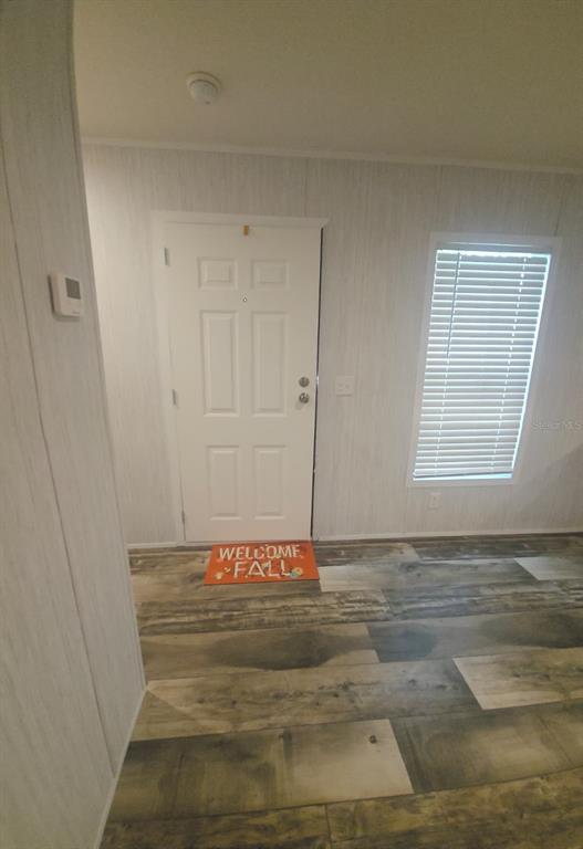 An interior view of an entryway featuring a white door, wood-look flooring, and a window — 862 NE COLDWATER AVENUE, LAKE CITY, FL