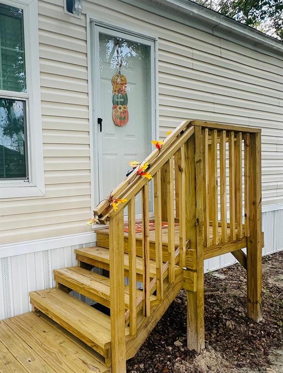 A wooden staircase with a railing leads to the front door of a mobile home — 862 NE COLDWATER AVENUE, LAKE CITY, FL