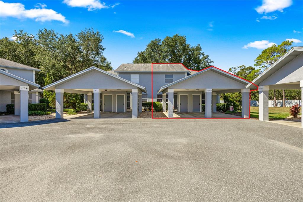 Exterior view of a multi-unit residential building with covered carports and gray siding — 11043 W HARBOR WATCH LOOP, CRYSTAL RIVER, FL
