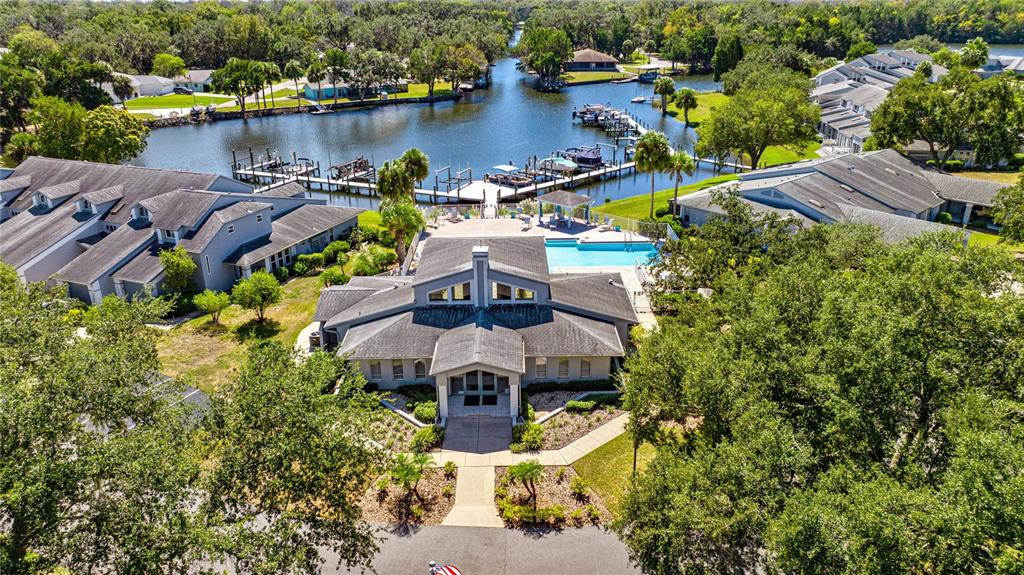 An aerial view shows a community clubhouse with a pool, docks, and surrounding buildings — 11043 W HARBOR WATCH LOOP, CRYSTAL RIVER, FL