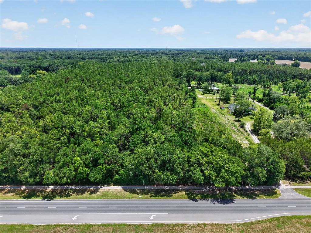 An aerial view shows a dense forest bordering a multi-lane highway — 000 W NEWBERRY ROAD, NEWBERRY, FL