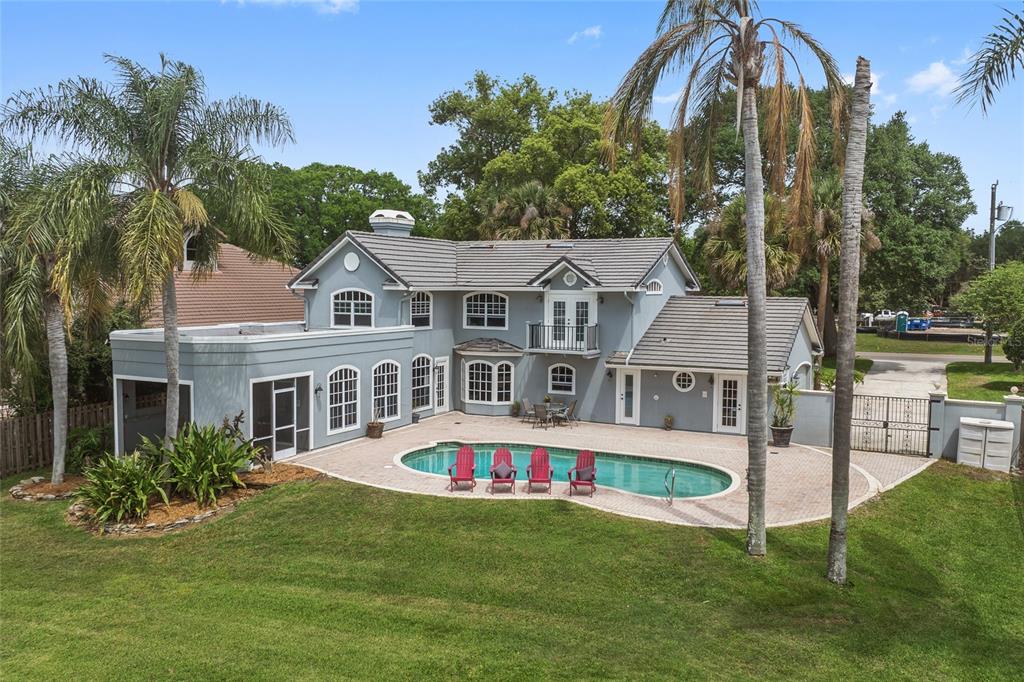 A two-story gray house with a swimming pool and a large grassy backyard — 9620 MAYWOOD DRIVE, WINDERMERE, FL