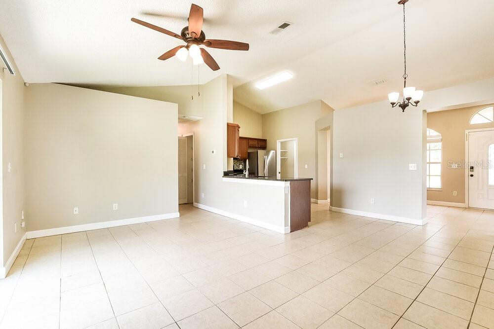 An open-concept living area features tile flooring, a ceiling fan, and a kitchen with dark cabinetry — 1306 SILVERTHORN DRIVE, ORLANDO, FL
